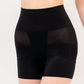 Black shapewear shorts worn by a person on a plain background